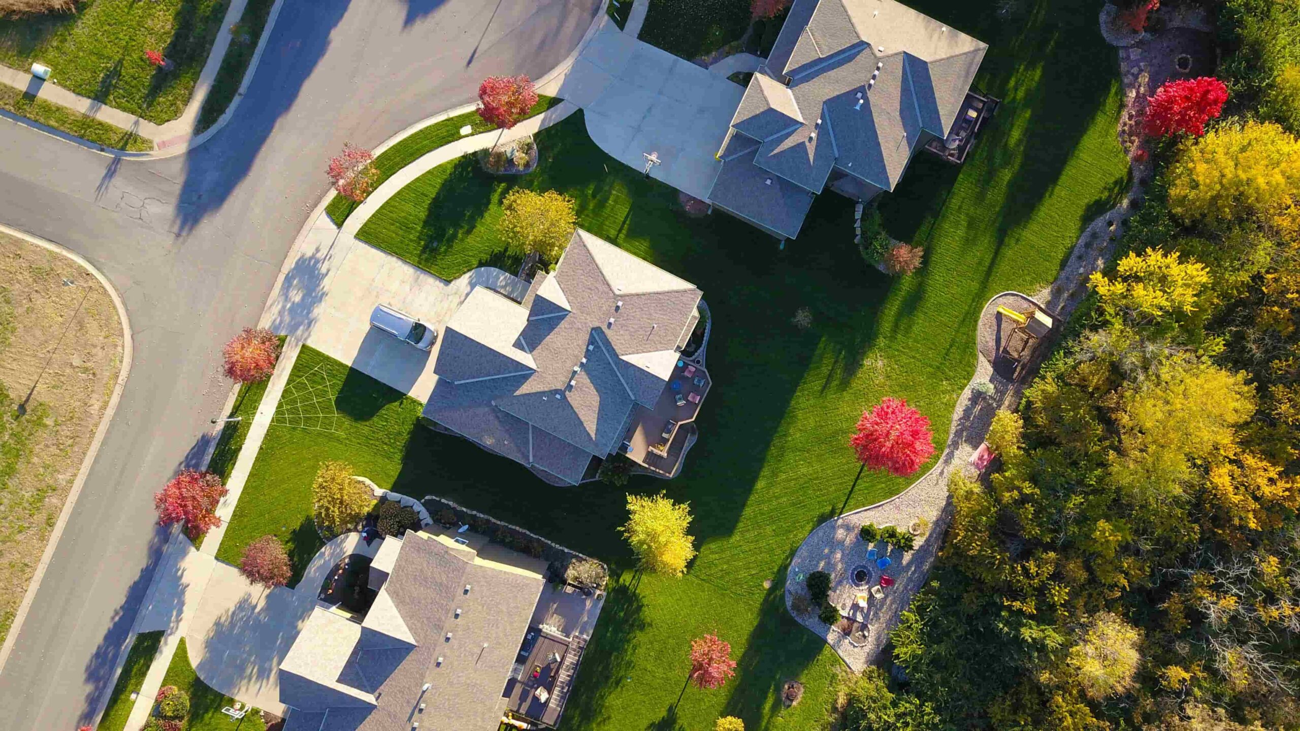 Aerial view of suburban homes with tree-lined streets and manicured lawns in the Greater Toronto Area.